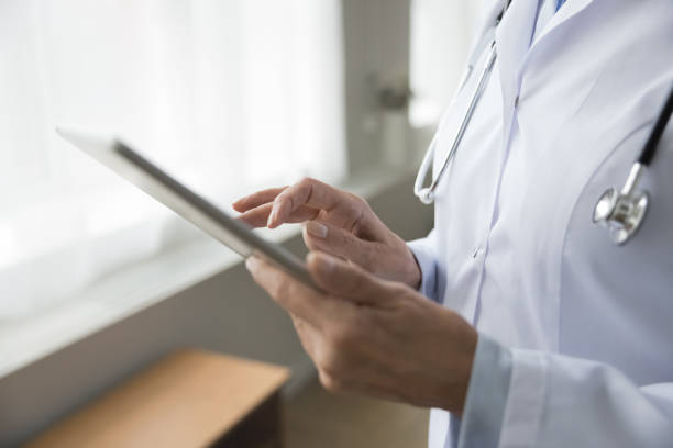 Close up female therapist working on digital tablet, conduct virtual consultation, review patient disease history, discuss symptom, provide medical advice, recommendations using telemedicine platforms